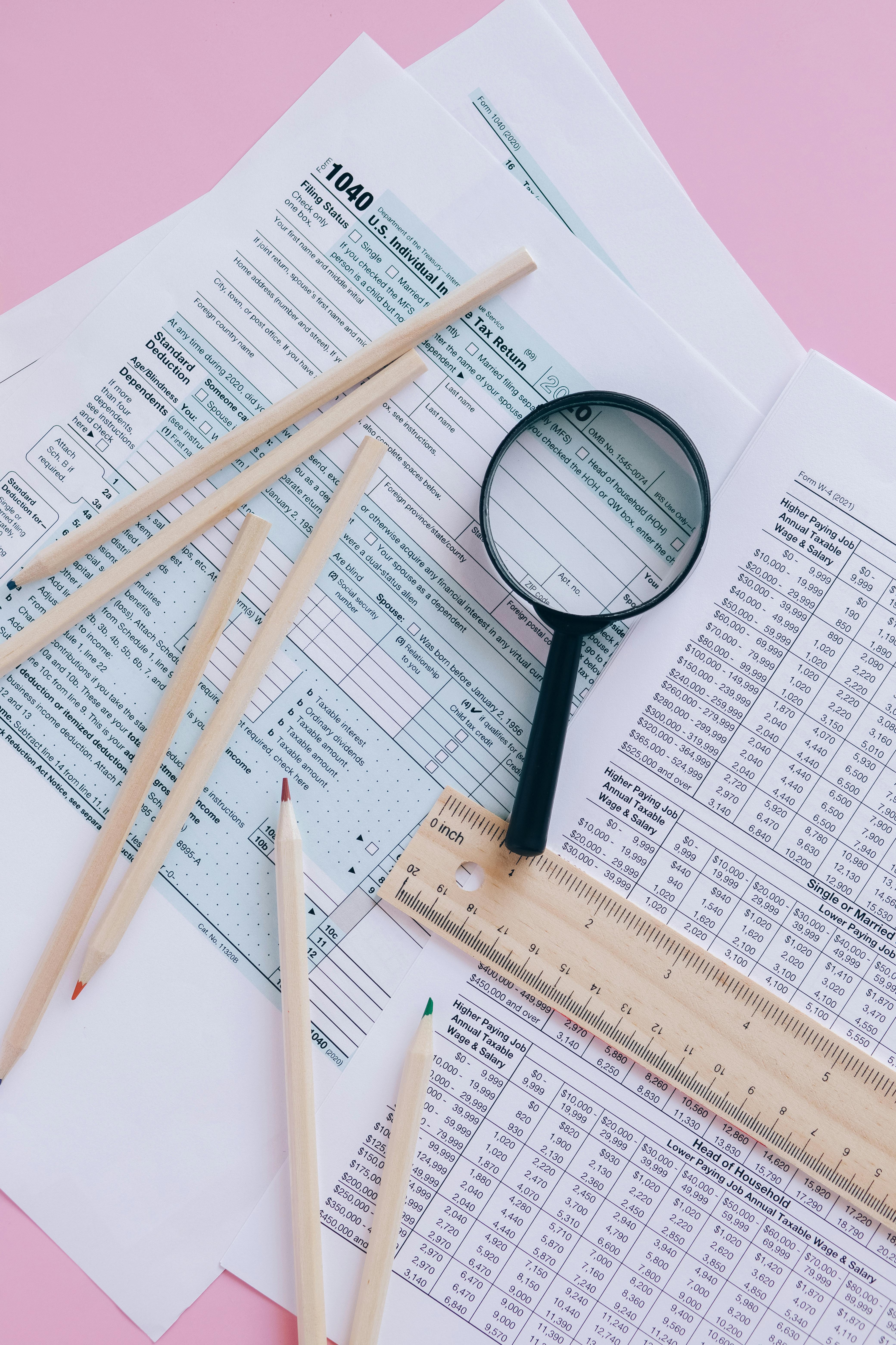 1040 tax forms with magnifying glass for careful tax review and planning